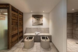 a bathroom with a bench and two wicker stools at Apart Forum in Ischgl