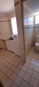 une salle de bain avec toilettes, lavabo et fenêtre dans l'établissement Kalbarri Holiday Villas B, à Kalbarri 21 autres photos