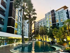 a pool in a city with palm trees and buildings at The private Paradise Two-bedroom condo Only women, shared accommodation in North Pattaya