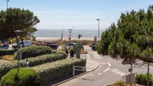 a group of people walking down a street near the beach at La Villa Rose-Marie in Saint-Brevin-les-Pins