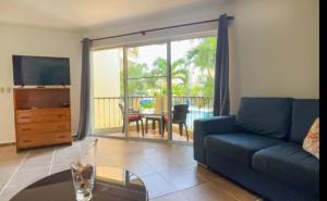 a living room with a couch and a tv and a table at Garden Condos 10, 2br Apt In Sosua Strip in Sosúa