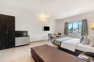 耶拉吉里Sterling Yelagiri的一间带床和桌子的酒店房间