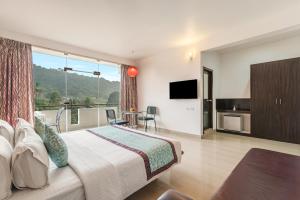 a bedroom with a large bed and a balcony at Sterling Yelagiri in Yelagiri