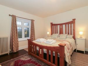 a bedroom with a wooden bed with two towels on it at Primrose Spinney in Ringwood