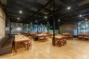 a restaurant with tables and couches and chairs at Sterling Yelagiri in Yelagiri
