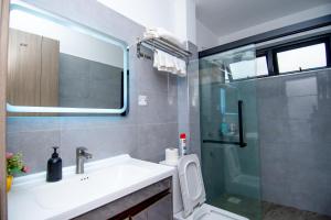 a bathroom with a sink and a glass shower at Sweet home in Nairobi +16 photos