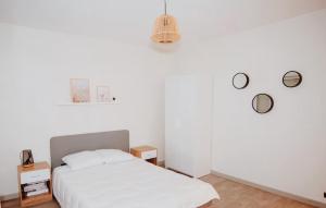 a white bedroom with a bed and two tables at "Envie Lyonnaise" Location - 14 personnes - Terrasse - WIFI fibre optic in Lyon