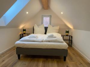 a bedroom with a bed with white sheets and pillows at barrierefreier Neubau im Zentrum in Marktbreit +2 photos