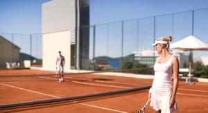 a woman standing on a tennis court holding a racket at Sun Gardens Dubrovnik in Dubrovnik