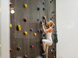 a woman is climbing a rock wall at Sun Gardens Dubrovnik in Dubrovnik