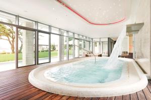 a large bath tub in a room with windows at Sun Gardens Dubrovnik in Dubrovnik