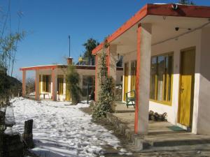 a house with snow on the ground in front of it at Janardan Resort Pangot, Nainital in Nainital