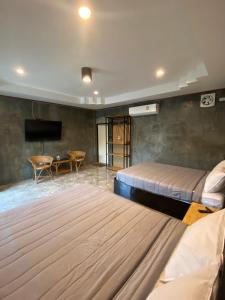a hotel room with two beds and a television at ชมดอยรีสอร์ท in Chiang Dao