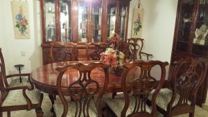 a wooden dining room table with chairs and a wooden cabinet at Almoloya De Juarez Colonial House in Almoloya de Juárez