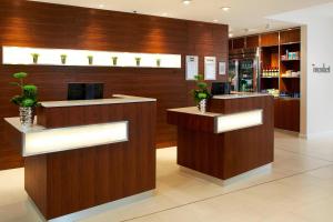 a lobby with two reception desks with potted plants at Courtyard by Marriott Aberdeen Airport in Dyce