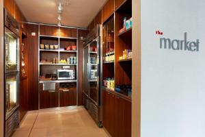 a kitchen with wooden cabinets and a refrigerator at Courtyard by Marriott Aberdeen Airport in Dyce