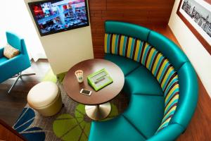a room with a blue chair and a table with a laptop at Courtyard by Marriott Aberdeen Airport in Dyce