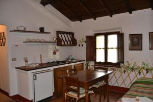 cocina con mesa, fogones y mesa en Two-room apartment in Tuscany country style, en La Lama