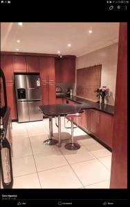 a kitchen with a table and stainless steel appliances at Emmanuel-Guest-House in Richards Bay