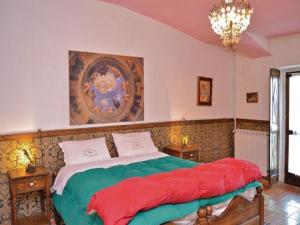 a bedroom with a large bed with red and green sheets at Castello dei Diamanti in Belvedere Langhe