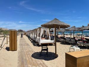 a beach with a row of chairs and an umbrella at Modern Apartman - Novamar 1 in Gran Alacant