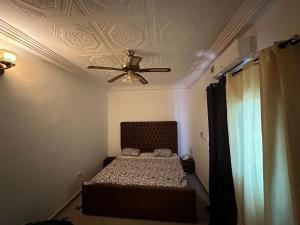 a bedroom with a bed and a ceiling fan at Villa Amina splendid and elegant in Ouagadougou