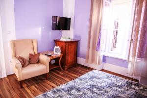 a living room with a chair and a tv at Rooms Cristal Roche in Rijeka