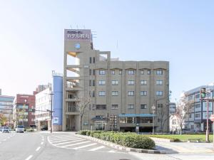 a large building on a city street with a road at Aqua Garden Hotel Fukumaru in Kagoshima