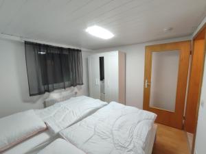 a white bed in a room with a window at Kaiserberg-Apartments "Auf dem Hohenstaufen" in Göppingen