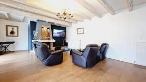 ein Wohnzimmer mit zwei Stühlen und einem Tisch in der Unterkunft Maison famille et spa in Cornimont