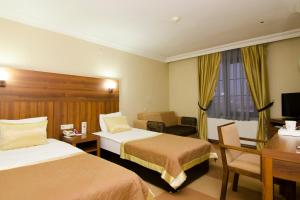 Un pat sau paturi într-o cameră la Grand Gebze Hotel