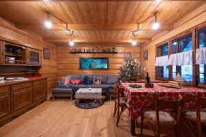 a living room with a table and a couch in a cabin at Chata pod lasem z balią i sauną in Myślenice