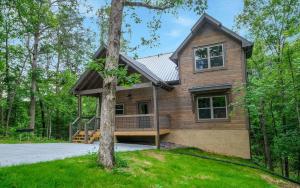 a wooden house with a tree in front of it at Rustic Timber in Sevierville