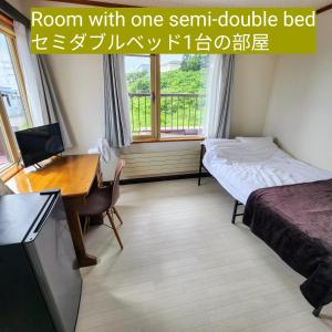 OdaitōGuest House ODAITO NEST的客房设有床、书桌、床和电脑