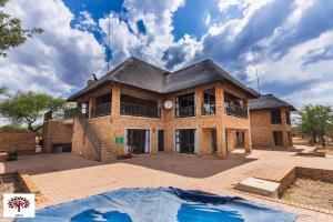 a house with a pool in front of it at Zebula Golf and Wildlife Estate - Spectacular View Pax 13 - Moi Signature Luxury villa in Mabula