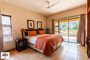 a bedroom with a bed and a large window at Zebula Golf and Wildlife Estate - Spectacular View Pax 13 - Moi Signature Luxury villa in Mabula