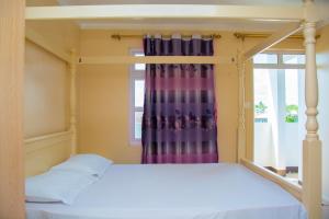 a bedroom with a canopy bed and a window at Sunshine Villa in Grand-Baie