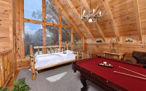een slaapkamer in een blokhut met een pooltafel bij Like a Comet in Sevierville