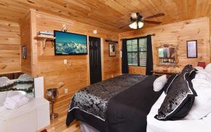 een slaapkamer met een bed en een flatscreen-tv bij Mountain Romance in Sevierville