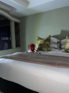 a large white bed with a tea kettle on it at Emmanuel-Guest-House in Richards Bay