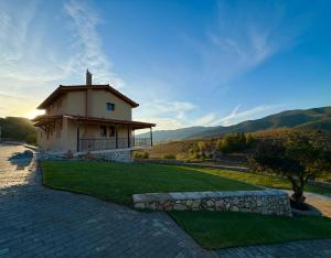 a small house on a hill with a green lawn at Alexi's House in Kalavrita