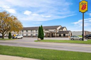 a building with a sign on the side of a street at Super 8 by Wyndham Waverly in Waverly