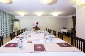a long table with tables and chairs in a room at Grand Gebze Hotel in Gebze