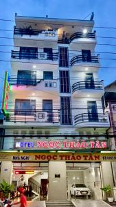 a tall white building with a sign on it at NGỌC THẢO TÂN Motel - CHÂU ĐỐC in Ấp Châu Thới