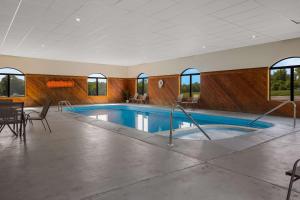 a swimming pool in a room with a table and chairs at Sleep Inn in Bolivar