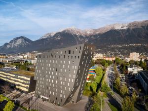 a rendering of a building with mountains in the background at Hilton Garden Inn Innsbruck Tivoli in Innsbruck