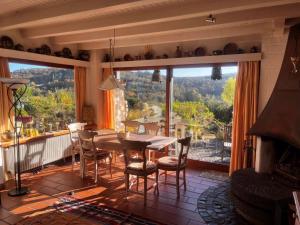 a dining room with a table and chairs and a large window at Ferienhaus am Breitenbach-Stausee in Hilchenbach