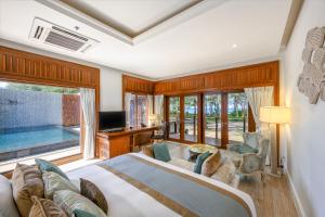 ein Schlafzimmer mit einem großen Bett und einem großen Fenster in der Unterkunft Maikhao Dream Villa Resort and Spa, Maikhao Phuket in Mai Khao Beach