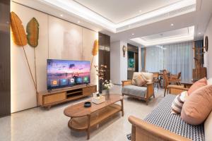 Televízia a/alebo spoločenská miestnosť v ubytovaní Sanya Haitang Bay Muyu Time Seaview Apartment