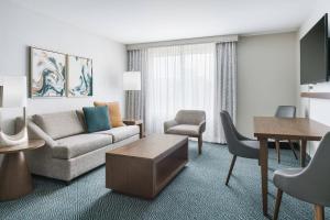 a living room with a couch and a table at Courtyard by Marriott Orlando Downtown in Orlando